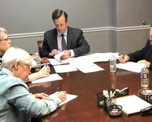 Carole Shinnick, SSND; Christine Beckett, SCN; and John Pavlik, OFM Cap with the lawyer signing paperwork for the sale of the office building